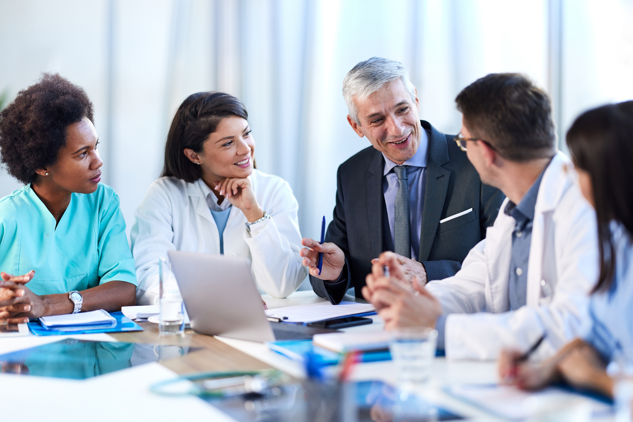 Healthcare executives and clinicians in a boardroom discussion